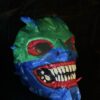 Hand-painted neon demon skull mask with sharp teeth and vibrant colors, 3D printed horror collectible.