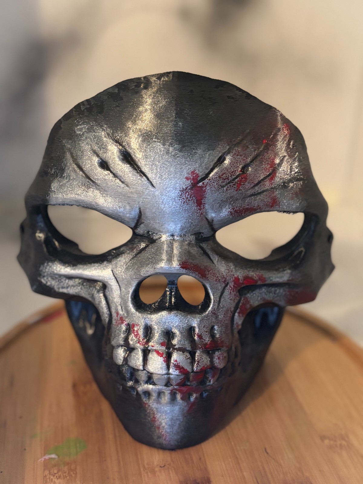 3D printed metallic skull mask with battle scars and red blood splatter details
